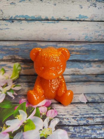 Ourson en résine époxy orange avec paillettes.