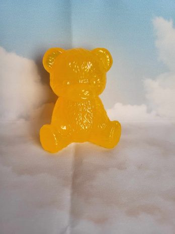 Ourson en résine époxy jaune avec paillettes.